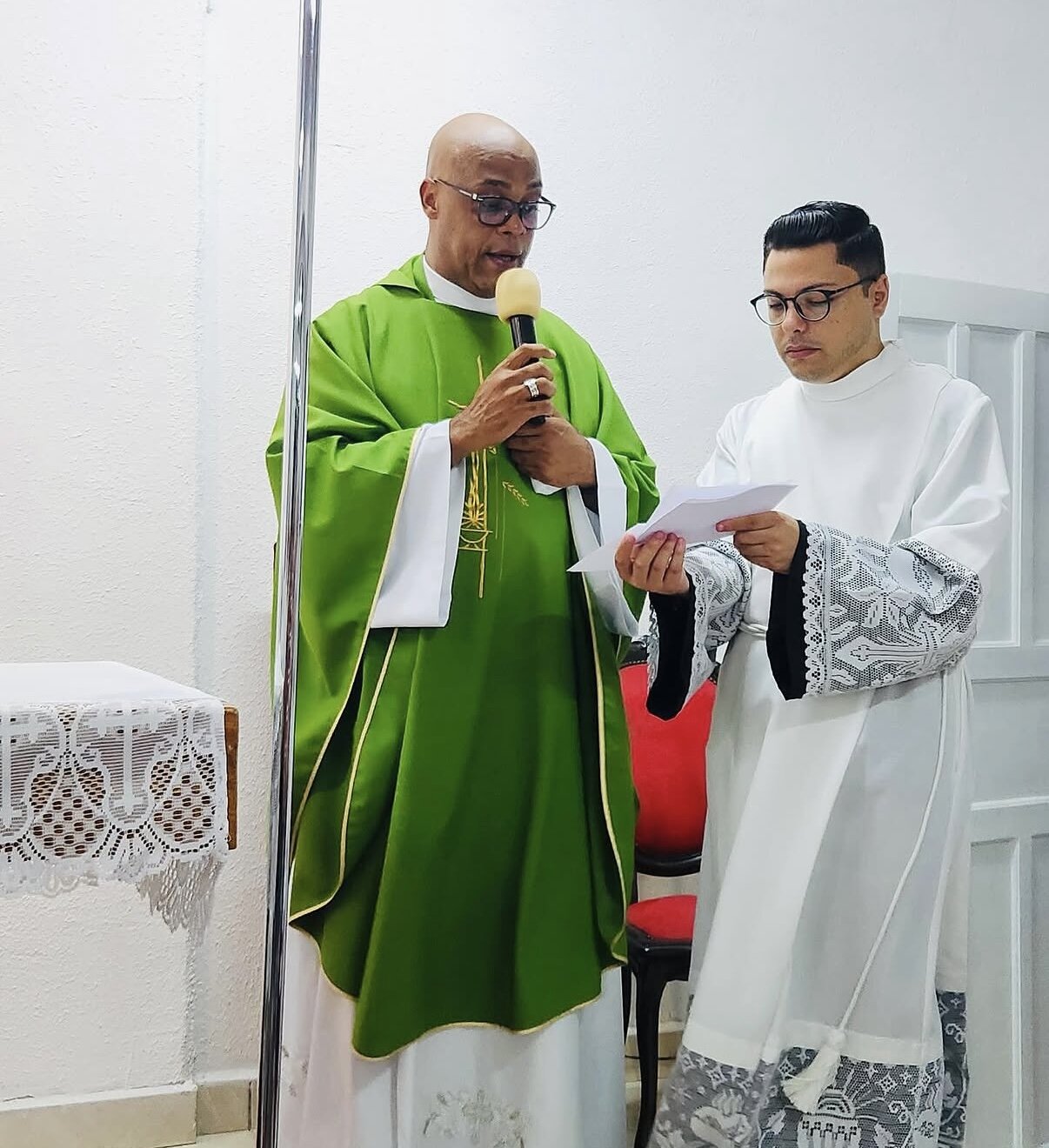 Padre e acólito com microfone