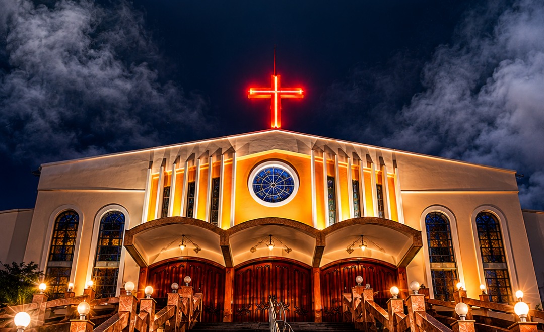Fachada da Igreja Matriz São Luiz Gonzaga à noite, com a cruz vermelha iluminada