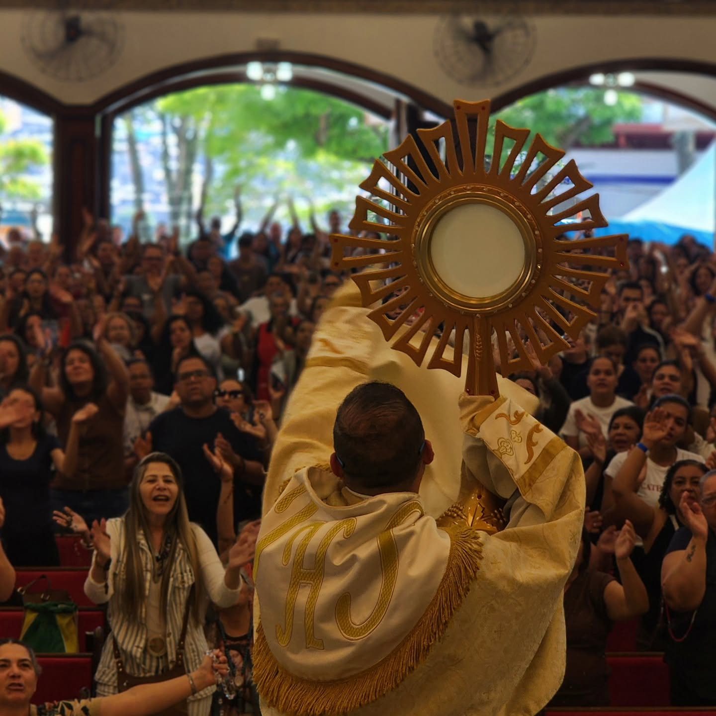 Sacerdote eleva o ostensório diante dos fiéis no Retiro de São Miguel Arcanjo