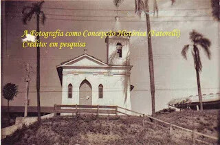A antiga Capela da Penhinha, branca, com campanário e coqueiros